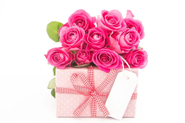 Bouquet of beautiful pink roses next to a pink gift with an empt Royalty Free Stock Photos