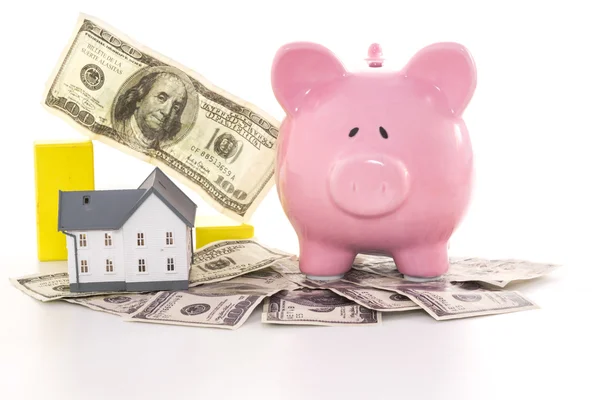 Pink piggy bank beside miniature house and graph — Stock Photo, Image