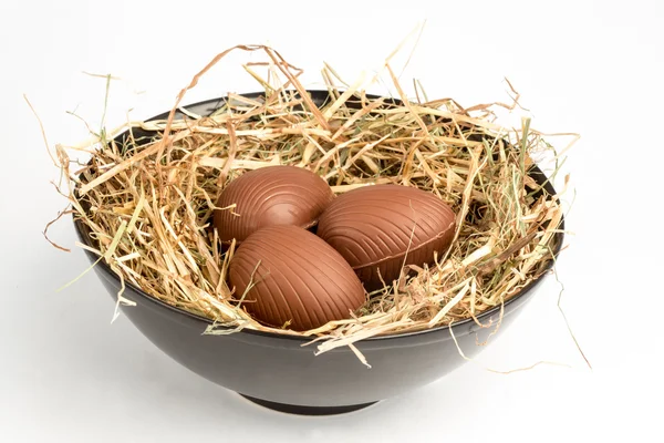 Ovos de Páscoa de chocolate em palha em tigela — Fotografia de Stock