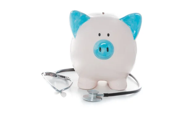 Stethoscope wrapped around blue and white piggy bank — Stock Photo, Image