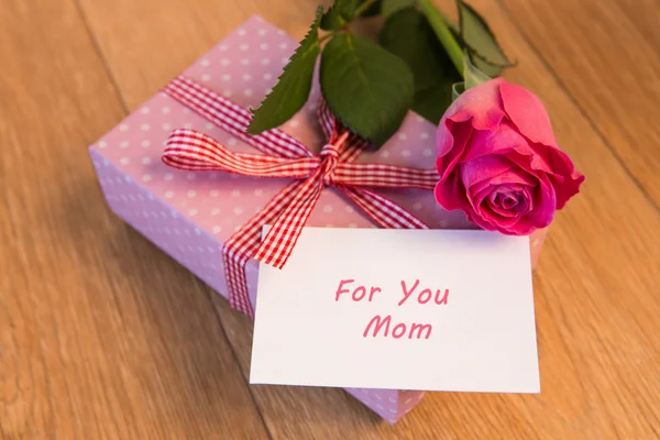 Roze gedrapeerde aanwezig zijn met moeders dag kaart en roze roos — Stockfoto
