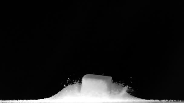 Cubo de azúcar cayendo en una pila de azúcar — Vídeos de Stock