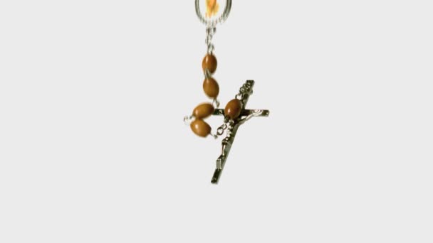 Rosary beads falling onto white surface — Stock Video