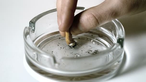 Погашение сигарет руками в пустой пепельнице — стоковое видео