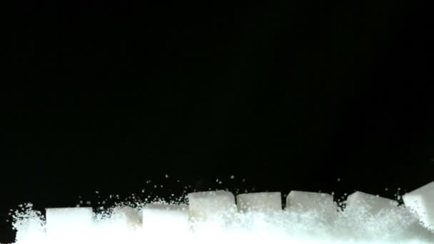 Cubos de açúcar que caem sobre uma pilha de açúcar — Vídeo de Stock