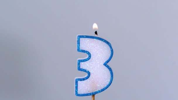 Three birthday candle flickering and extinguishing on blue background — Stock Video