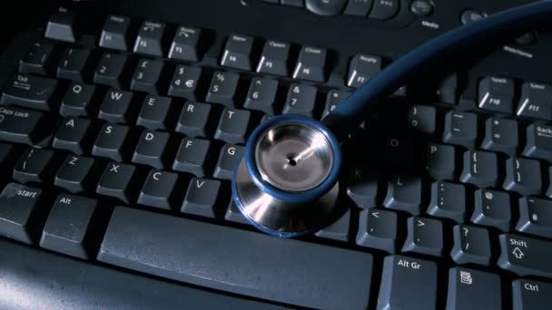 Stethoscope falling onto keyboard — Stock Video