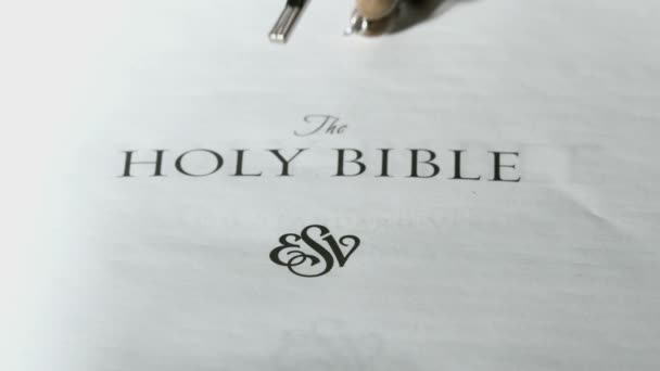 Rosary beads falling onto first page of holy bible — Stock Video