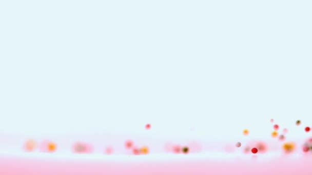 Hagelslag gieten op roze oppervlak — Stockvideo