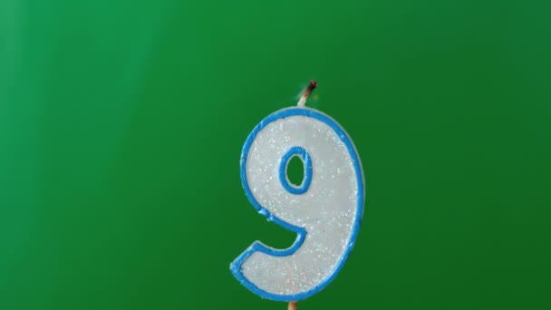 Nine birthday candle flickering and extinguishing on green background — Stock Video