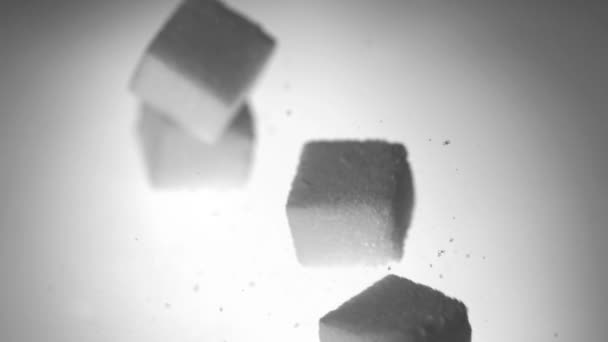 Четыре кубика сахара падают на белую поверхность — стоковое видео