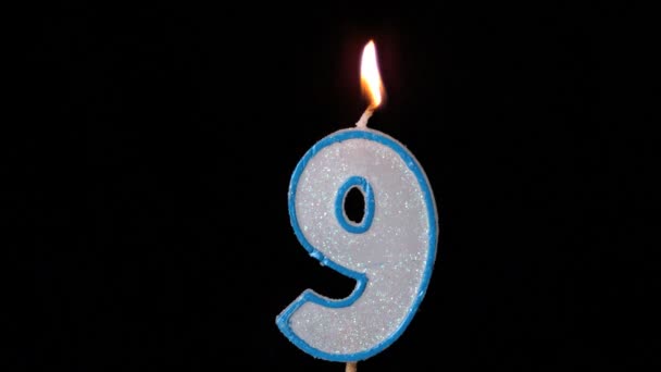 Nine birthday candle flickering and extinguishing on black background — Stock Video