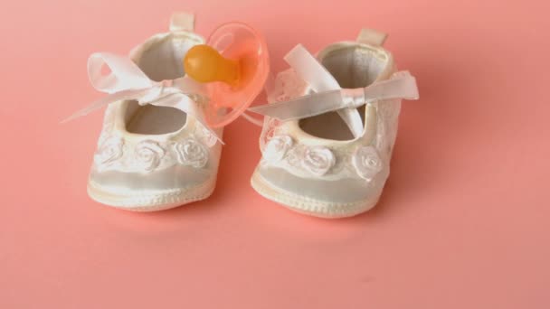 Roze fopspeen vallen op baby schoenen — Stockvideo