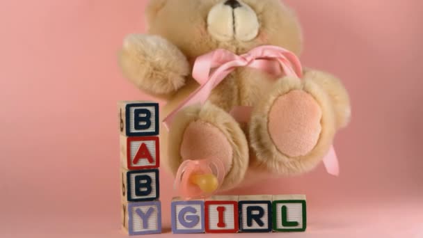 Teddybär fällt auf Babyklötze und rosa Beruhiger — Stockvideo