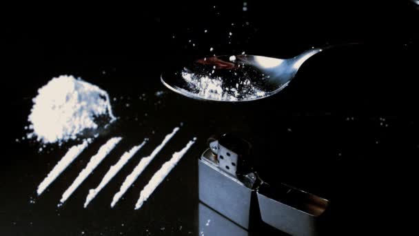 White drugs falling onto spoon beside lines larger pile and lighter — Stock Video