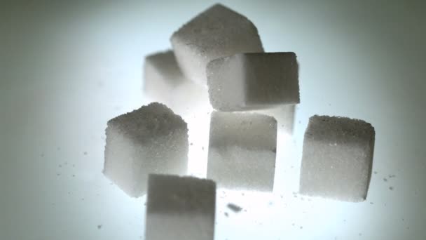 Sugar cube falling onto pile of cubes — Stock Video