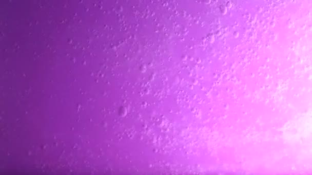 Wasser breitet sich auf violettem Hintergrund aus — Stockvideo