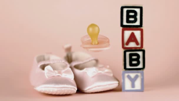 粉红色安抚奶嘴婴儿鞋和婴儿块落 — 图库视频影像