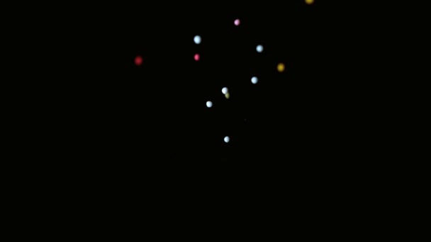 Colourful sprinkles pouring onto black surface — Stock Video