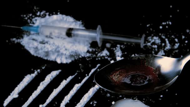 Шприц падает на белый наркотик, пока препарат готовится на ложке — стоковое видео
