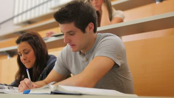 Étudiant levant les yeux de la conférence et souriant — Video