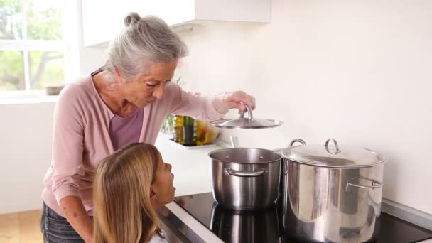 Meisje gelukkig koken met haar grootmoeder — Stockvideo