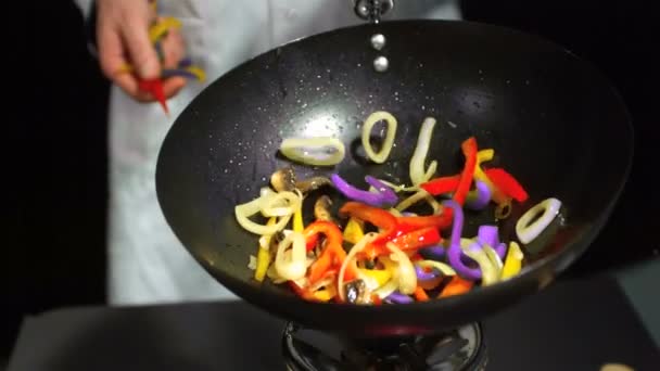 Koch wirft gemischtes Gemüse in den Wok — Stockvideo