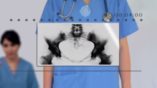 Infirmière utilisant écran tactile numérique pour regarder diverses images médicales — Video