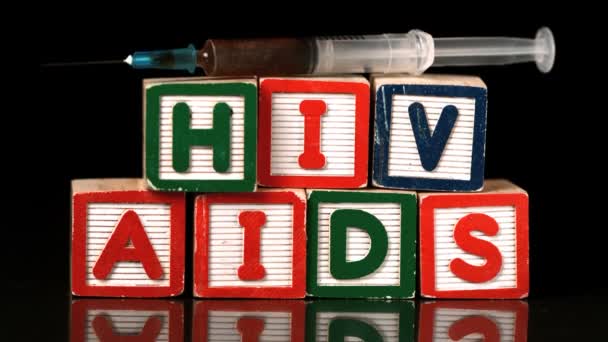 AIDS ve HIV yazım bloklar üzerinde düşen şırınga — Stok video