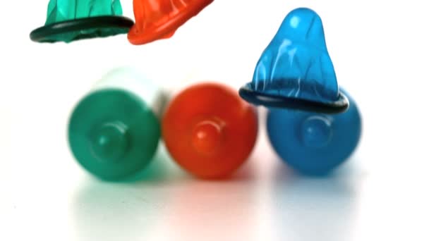 Красочные презервативы, падающие перед взорванными презервативами — стоковое видео