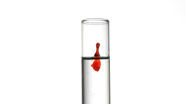 Gota de sangre cayendo en el tubo de ensayo de agua de cerca — Vídeo de stock