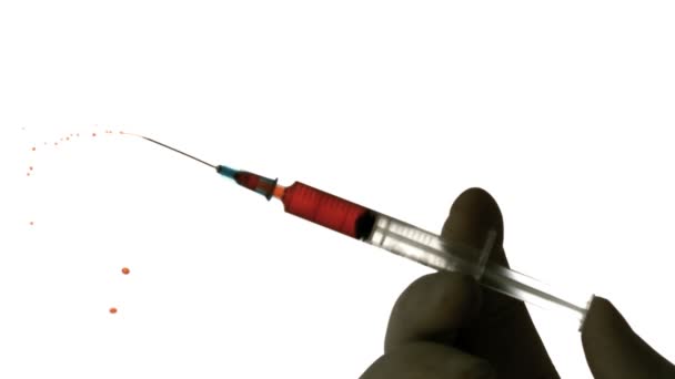 Hand injecting blood from syringe — Stock Video