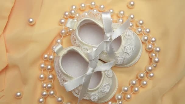 White baby booties with string of pearls — Stock Video