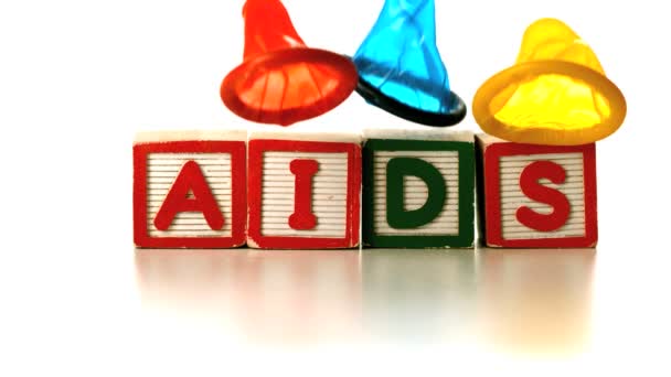 色彩缤纷的避孕套落在拼写检查艾滋病的块 — 图库视频影像