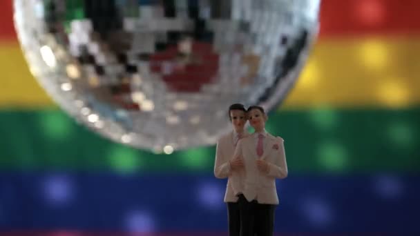 Gay groom cake toppers in front of rainbow flag — Stock Video