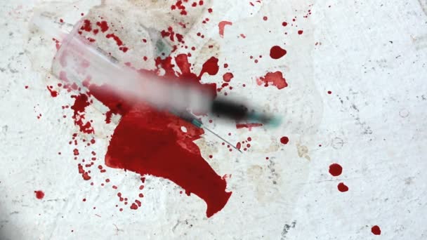 Syringes falling on bloody surface — Stock Video