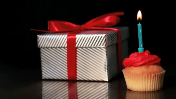 Kerze auf Cupcake neben Geschenk geblasen — Stockvideo