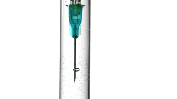 Syringe blowing bubbles in test tube of water close up — Stock Video