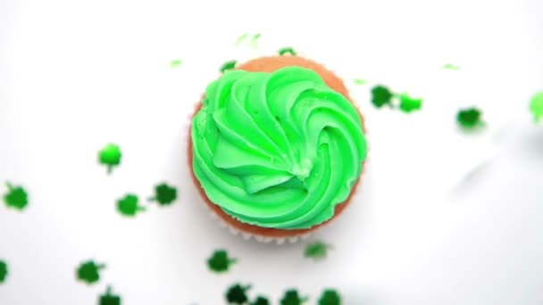 St patricks day cupcake rotiert mit grünem Shamrock Konfetti fallen — Stockvideo