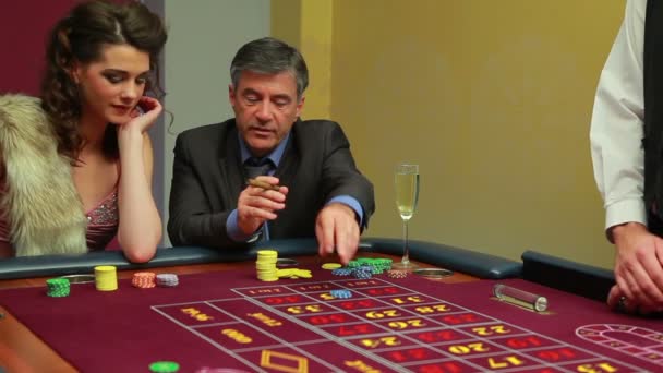 Femme et homme placent des paris sur la table de roulette — Video