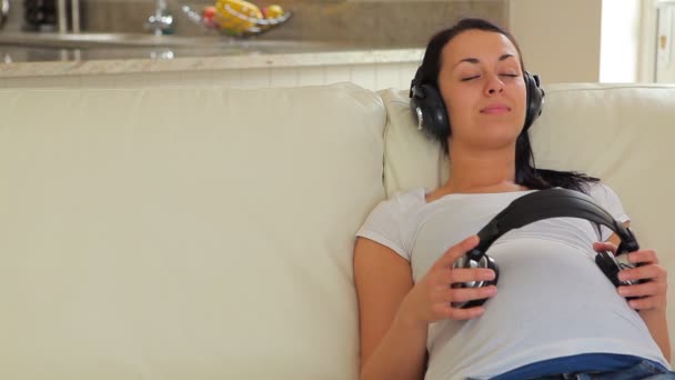 Mujer escuchando música con auriculares en el vientre — Vídeo de stock