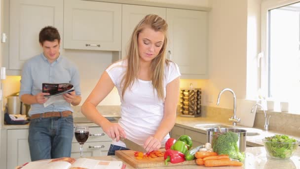 Vrouw hakken groenten dan voeding man schertsend — Stockvideo