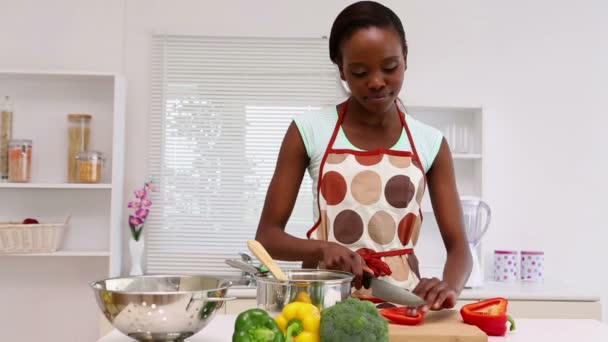 Женщина режет овощи на кухне — стоковое видео
