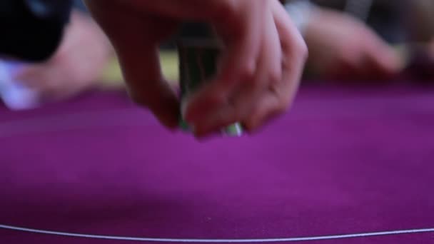 Hombre poniendo fichas en la mesa y otros lanzando cartas — Vídeos de Stock