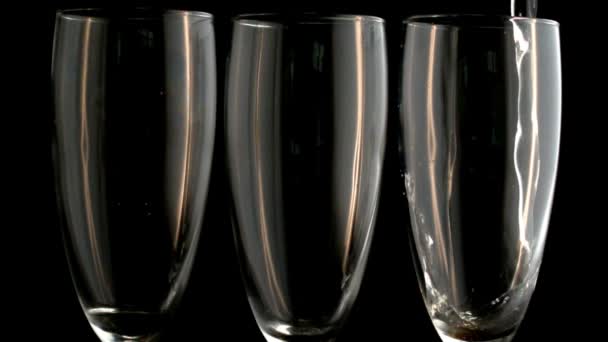 Three champagne flutes with one being filled — Stock Video