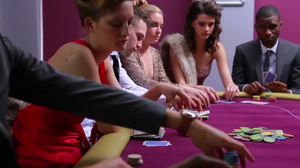 À la table de poker placer des paris femme en robe rouge va tout en — Video