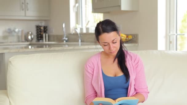 Женщину, читающую книгу, удивляет муж с цветами — стоковое видео