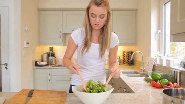 Vrouw mengen salade in de keuken — Stockvideo