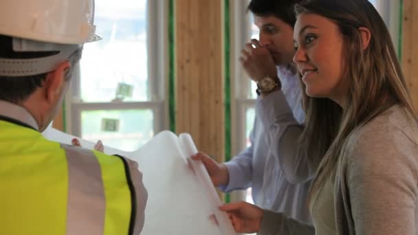 Architect showing blueprints to couple — Stock Video