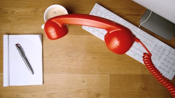 Красный телефонный приемник падает на офисный стол — стоковое видео